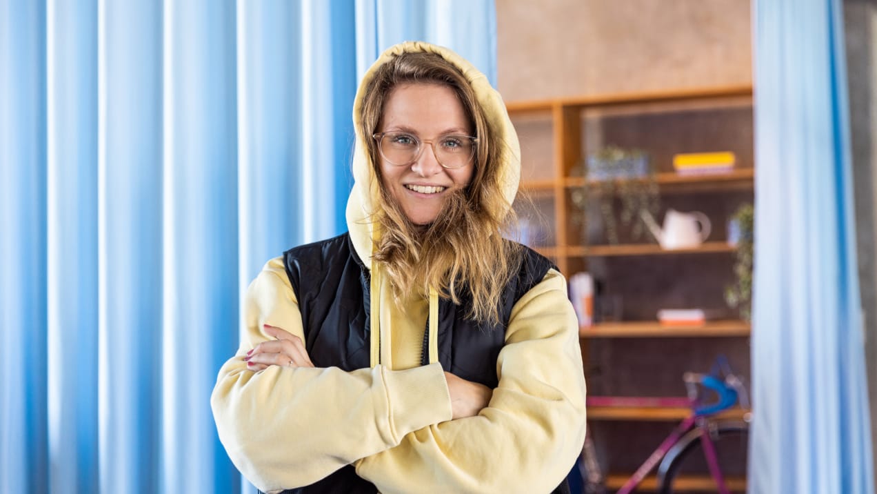 Lena mit Hoodie und Lächeln im Office