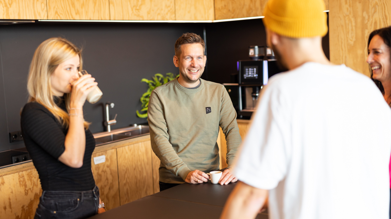 Colleagues chatting during coffee break in the kitchen